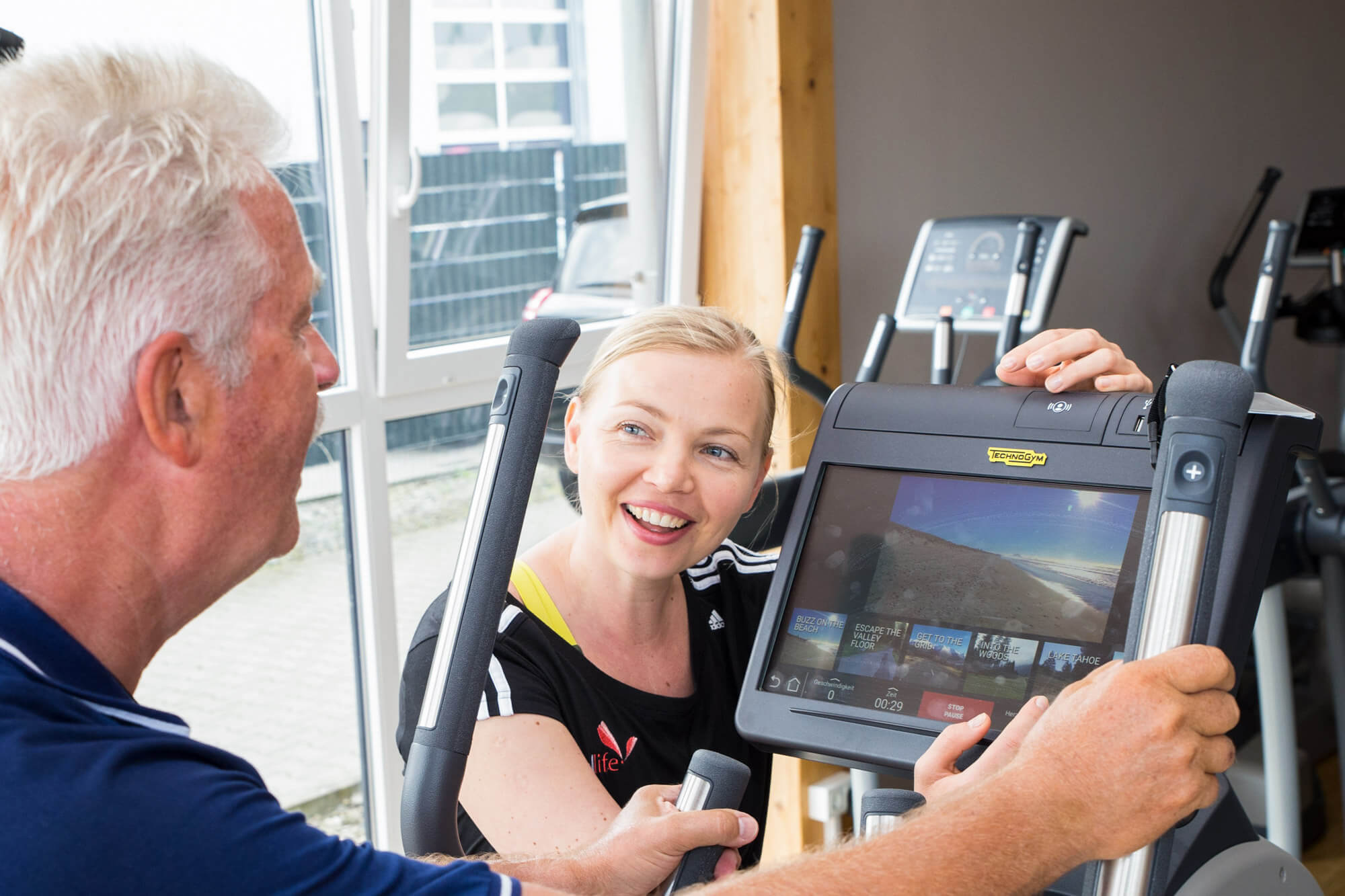 Trainerin begleitet ein Mitglied beim Ausdauertraining